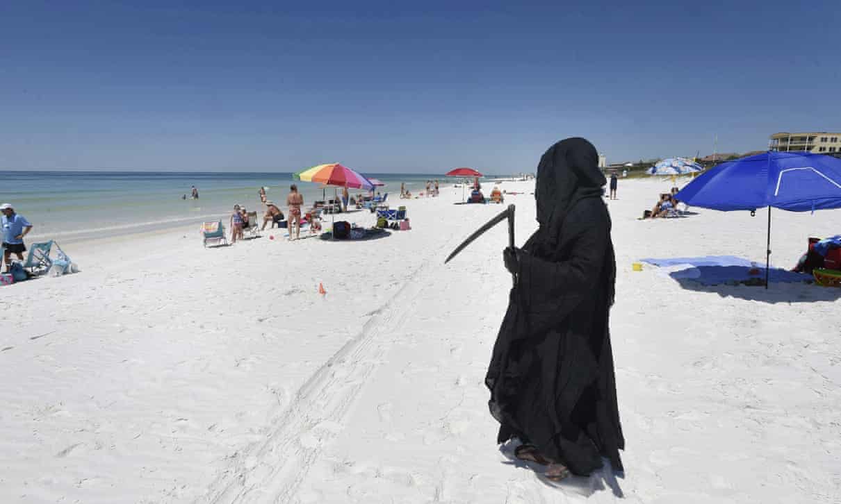 Hombre vestido de "muerte" acecha en playa de Florida para protestar contra la reapertura