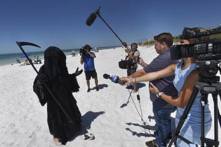 Hombre vestido de "muerte" acecha en playa de Florida para protestar contra la reapertura