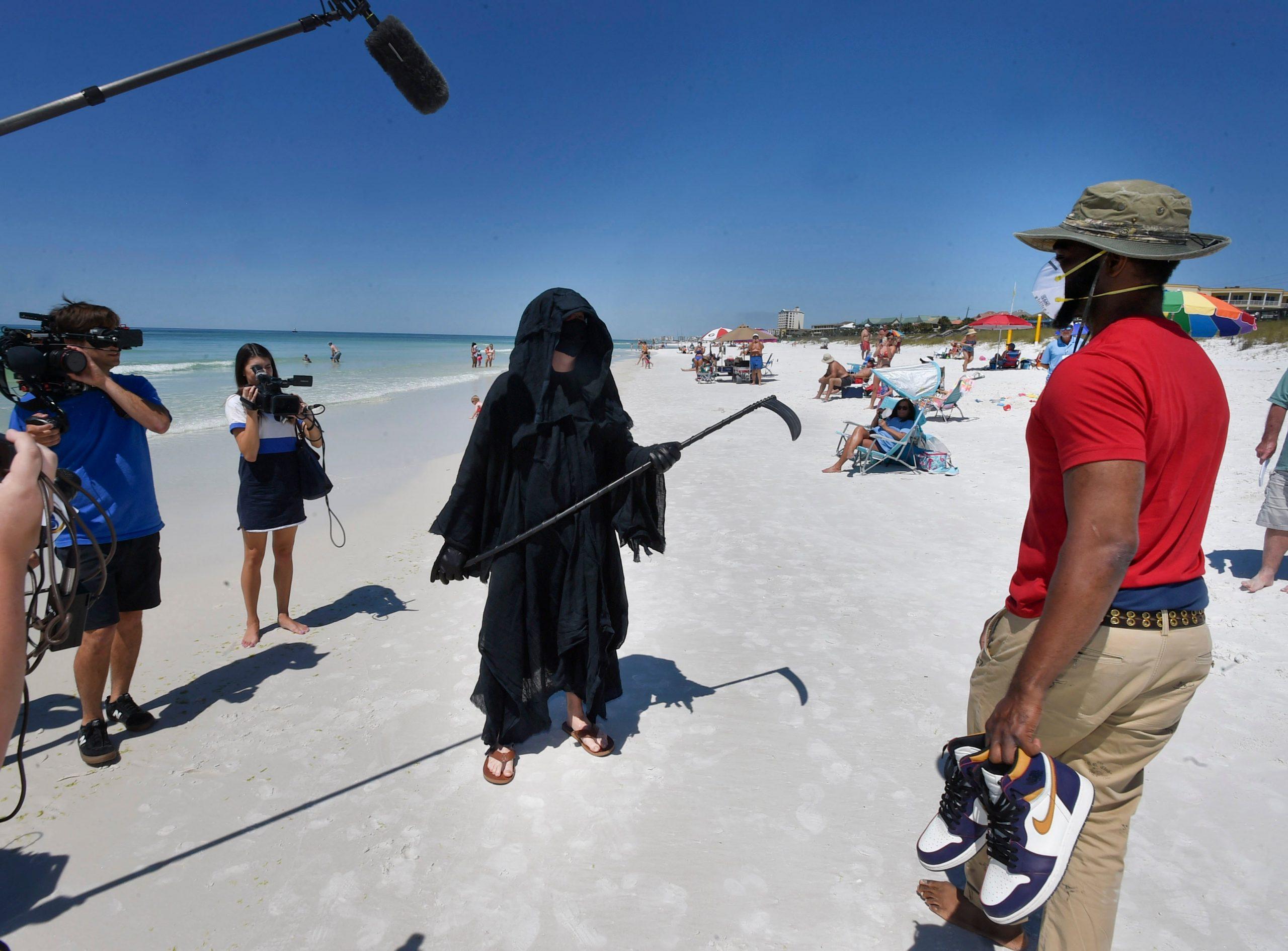 Hombre vestido de "muerte" acecha en playa de Florida para protestar contra la reapertura
