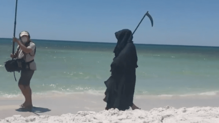 Hombre vestido de "muerte" acecha en playa de Florida para protestar contra la reapertura