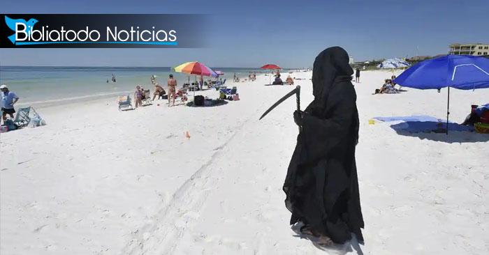Hombre vestido de "muerte" acecha en playa de Florida para protestar contra la reapertura