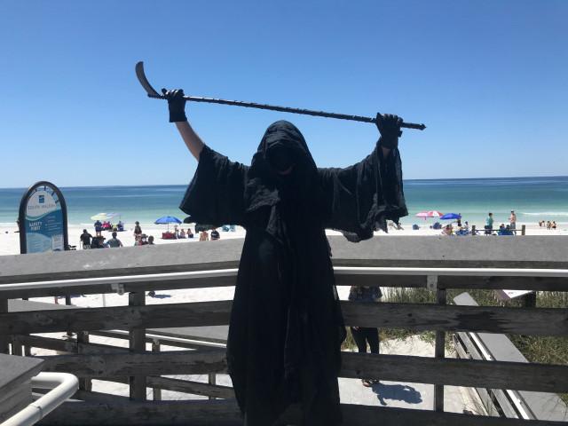 Hombre vestido de "muerte" acecha en playa de Florida para protestar contra la reapertura